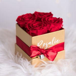 scatola dorata quadrata con 4 rose stabilizzate di color rosso e nastro rosso
